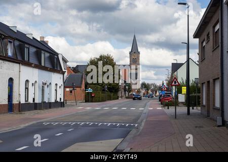 AALST, BELGIEN, 3. OKTOBER 2024: Blick auf die Hauptstraße durch das Zentrum von Herdersem mit Pfarrkirche und Gebäuden. Herdersem ist eine Gemeinde und muni Stockfoto