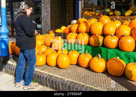 Frau, die Kürbisse in einem Laden in der Hunstanton High Street ansieht - bereit für Halloween. Stockfoto