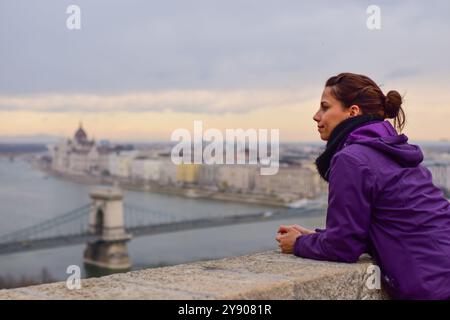 Junge Frau genießt die Skyline, einschließlich Parlamentsgebäude und Donau, Budapest, Ungarn, Europa Stockfoto