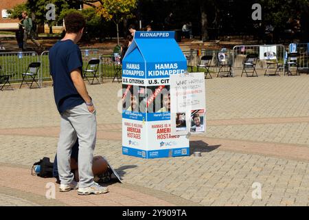 College Park, Maryland, USA. Oktober 2024. Ein „Geiselplatz“, der im Geiste dem in Tel Aviv ähneln soll, wurde am Hornbake Plaza auf dem Campus der University of Maryland in College Park, MD, am ersten Jahrestag des Angriffs vom 7. Oktober errichtet. Auf dem Bild sieht jemand einen der großen Milchkartons auf dem Platz, der Informationen über einige der Geiseln zeigte. (Kreditbild: © Evan Golub/ZUMA Press Wire) NUR REDAKTIONELLE VERWENDUNG! Nicht für kommerzielle ZWECKE! Stockfoto