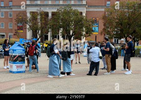 College Park, Maryland, USA. Oktober 2024. Ein „Geiselplatz“, der im Geiste dem in Tel Aviv ähneln soll, wurde am Hornbake Plaza auf dem Campus der University of Maryland in College Park, MD, am ersten Jahrestag des Angriffs vom 7. Oktober errichtet. Hier abgebildet, stehen Leute auf dem Platz und hören jemandem zu. Ebenfalls zu sehen ist eine der großen Milchkartons, die Informationen über einige der Geiseln zeigte. (Kreditbild: © Evan Golub/ZUMA Press Wire) NUR REDAKTIONELLE VERWENDUNG! Nicht für kommerzielle ZWECKE! Stockfoto