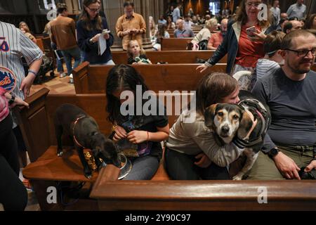 New York, New York, USA. Oktober 2024. Haustierbesitzer umarmen und lieben ihre Hunde in den Bänken. Die Menschen brachten ihre geliebten Haustiere zur Trinity Church in der Wall Street, Manhattan, wo eine Zeremonie zum Segen der Tiere stattfand. Die Zeremonie ist eine katholische Zeremonie, die die Liebe des hl. Franz de Assis zu den Tieren feiert und auf oder nahe dem 4. Oktober fällt, je nachdem, an welchem Tag sie fällt. (Kreditbild: © Bianca Otero/ZUMA Press Wire) NUR REDAKTIONELLE VERWENDUNG! Nicht für kommerzielle ZWECKE! Stockfoto