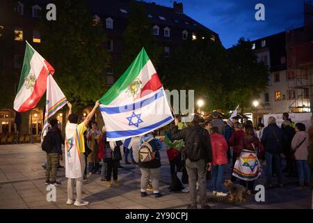 Koblenz, Deutschland. Oktober 2024. Die Teilnehmer einer Demonstration gegen den Antisemitismus halten israelische und iranische Fahnen aus der Zeit des Schahs am Jahrestag des Angriffs der Hamas auf Israel. Quelle: Thomas Frey/dpa/Alamy Live News Stockfoto