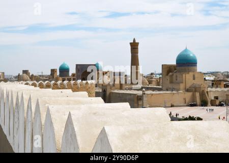 Blick auf Buchara mit Po-i-Kalan-Architekturkomplex und Kalyan-Minarett von der mittelalterlichen Archenfestung in Usbekistan. Selektiver Fokus auf die Festungsmauer Stockfoto