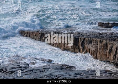 Mächtige Wellen schlagen gegen die geschichteten Felsformationen der Küste von Mullaghmore in Kilkilloge, County Sligo, Irland Stockfoto