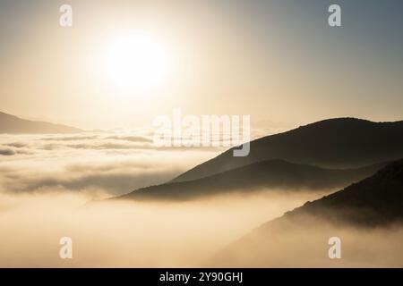 Bernsteinfarbener Sonnenaufgang über niedrigen Wolken und Bergrücken in Los Angeles, Kalifornien. Stockfoto