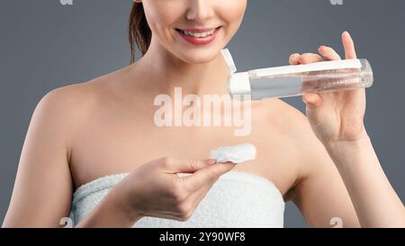 Rothaarige Millennial Frau Mit Lotion Und Baumwolle Pad, Weißer Hintergrund Stockfoto