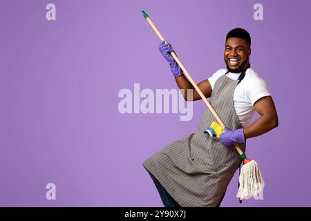 Portrait Of Funny Black Man In Schürze Mit Mopp In Den Händen Stockfoto