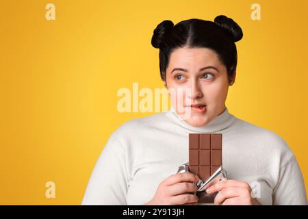 Portrait Von Pensivem Adipösen Mädchen Mit Chocolate Bar In Den Händen Stockfoto