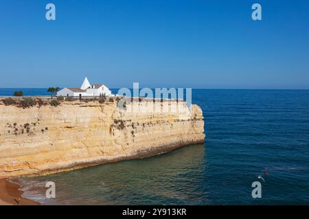 Capela da Nossa Senhora da Rocha, eine kleine Kapelle auf einer atemberaubenden Klippe, in der Küstenstadt Alporchinhos an der Algarve, Portugal Stockfoto