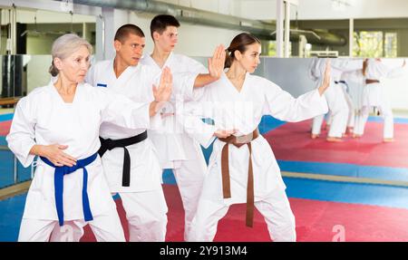 Menschen in Kimonos üben Schläge während des Trainings der Kampfkunst Stockfoto