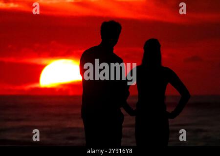 Isle Of Palms, Usa. Oktober 2024. Ein Paar, umgeben vom Sonnenaufgang, hält am Strand des Wild Dunes Resort, 7. Oktober 2024 in Isle of Palms, South Carolina. Quelle: Richard Ellis/Richard Ellis/Alamy Live News Stockfoto