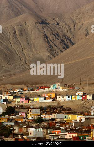 Blick auf das thermoelektrische Kraftwerk und felsige Überdachungen entlang der nahe gelegenen Küste, um Erosion zu verhindern, Tocopilla, Chile Stockfoto