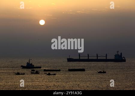 Bulk Carrier Queen Busan Schiff, Schlepper und Fischerboote, die bei Sonnenuntergang im Pazifik vor dem Hafen von Tocopilla, Chile, vertäut sind Stockfoto