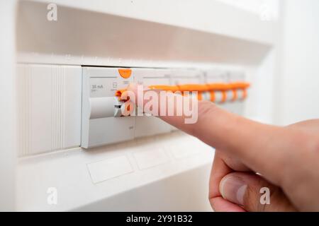 Nahaufnahme von Mann Hand und Elektriker mit elektrischem Sicherungskasten, Stromversorgung mit Wartung des Hauptleistungsschalters prüfen. Ingenieur, Techniker Stockfoto