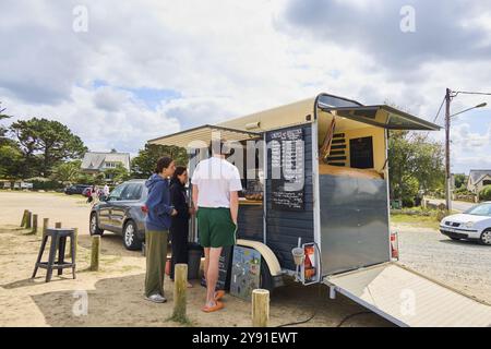 Kleiner Food Truck, der Crepes verkauft, mit Kunden im Vordergrund, Plage de Tourony, Tournoy Beach, Cote de Granit Rose, Bretagne, Frankreich, Europa Stockfoto