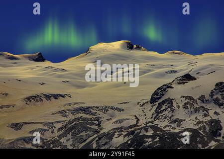 Schneebedeckte Berge unter blauem Himmel und grün-gelbe Aurora bei Nacht, Monte Rosa Massiv, Dent Blanche, Dufourspitze, Zermatt, Kanton Wallis, Swit Stockfoto