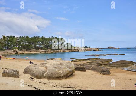 Plage de Tourony, Tournoy Beach, Cote de Granit Rose, Bretagne, Frankreich, leichter Sand und Badegäste am Strand bei ruhigem Wetter. Runde Granitfelsen mit Stockfoto