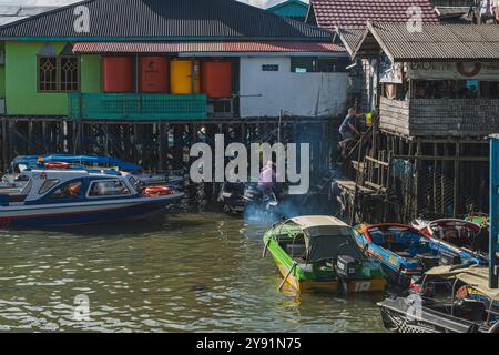 Balikpapan, Indonesien - 26. Juni 2024. Einer der drei Passagiere des Schnellbootes am Bootshafen stieg eilig die Holztreppe in Richtung der alten Stockfoto