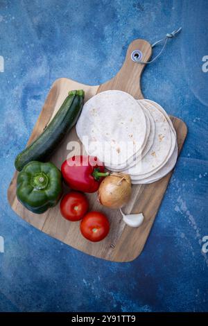 Ein lebendiges und farbenfrohes Sortiment an frischem Gemüse gepaart mit Tortillas, ideal für gesunde Mahlzeiten Stockfoto