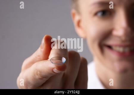 Frau, die Kontaktlinse auf der Fingernaht hält, Konzeptalternative zur Brille Stockfoto