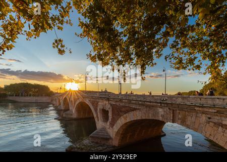 Goldener Sonnenuntergang über dem Fluss Garonne und Pont Neuf in der Innenstadt von Toulouse. Diese Bogenbrücke gilt als ein Meisterwerk der Renaissance. Die Brücke i Stockfoto