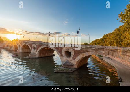 Goldener Sonnenuntergang über dem Fluss Garonne und Pont Neuf in der Innenstadt von Toulouse. Diese Bogenbrücke gilt als ein Meisterwerk der Renaissance. Die Brücke i Stockfoto
