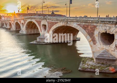 Goldener Sonnenuntergang über dem Fluss Garonne und Pont Neuf in der Innenstadt von Toulouse. Diese Bogenbrücke gilt als ein Meisterwerk der Renaissance. Die Brücke i Stockfoto