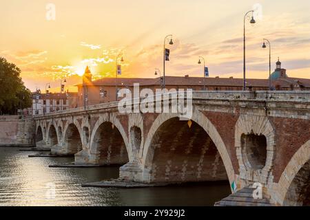 Goldener Sonnenuntergang über dem Fluss Garonne und Pont Neuf in der Innenstadt von Toulouse. Diese Bogenbrücke gilt als ein Meisterwerk der Renaissance. Die Brücke i Stockfoto