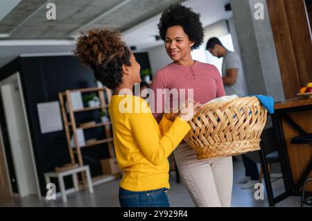 Die schwarze Tochter hilft Mutter, Haushalts- und Hausarbeiten zusammen zu erledigen Stockfoto