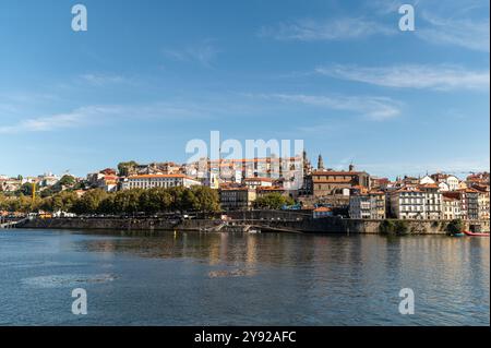 Porto, Portugal - 12. September 2024 : Eine bezaubernde aussicht auf den Fluss mit farbenfrohen Gebäuden unter klarem blauem Himmel. Stockfoto