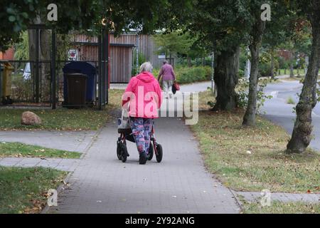 Eine Rentnerin schiebt am Dienstag 17.09.2024 Ihren Rollator durch den Stadtteil Groß Klein der Hanse- und Universitätsstadt Rostock. Der Stadtbezirk ist insbesondere gekennzeichnet von einem hohen Altersdurchschnitt und Menschen mit Migrationshintergrund. Hinzu kommt, das in dem Stadtgebiet zahlreiche Senioren leben die von ihren Bezügen kaum den Lebensunterhalt bestreiten können. Damit ist das Wohngebiet ein Spiegel der Gesellschaft in der immer wieder Bürger im Alter nur eine Grundsicherung erhalten. *** Eine Rentnerin schiebt ihren Wanderer durch den Groß Klein Stadtteil der Hanse und Univ Stockfoto