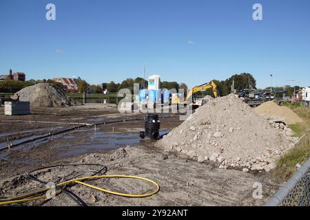 Baustelle in der Nähe des Kanals (Noordhollandsch Kanaal) mit Bentoniet fabriek (Bentonitfabrik), Bagger, Erdhaufen und Sand. Herbst, Oktober. Stockfoto