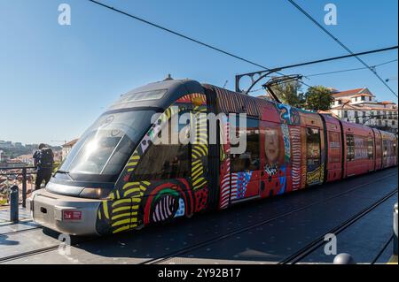 Porto, Portugal - 12. September 2024: Straßenbahn nähert sich an einem sonnigen Nachmittag dem Bahnsteig an der Brücke Dom Luis I in Porto Stockfoto