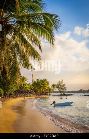 Wunderschöner Blick auf den atemberaubenden tropischen Strand in Grand Baie, Mauritius, mit feinem Sand und gesäumt von Kokospalmen bei Sonnenuntergang während der goldenen Stunde Stockfoto