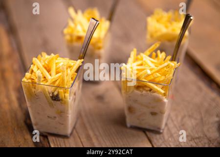 Kreative Vorspeise mit knusprigen Pommes frites, serviert in durchsichtigen Glasbehältern und einem Bad auf einem rustikalen Holztisch Stockfoto