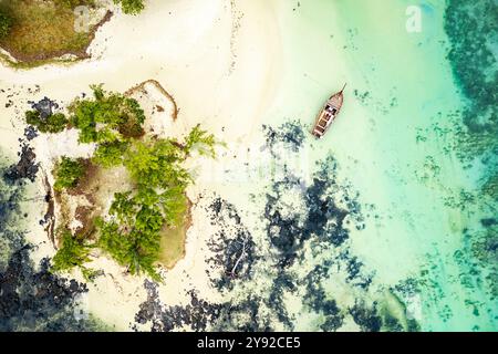 Atemberaubende Aussicht auf ein hölzernes Segelboot vor Anker am weißen Sandstrand der abgelegenen und paradiesischen Insel L'îlot Bernache, Mauritius Stockfoto