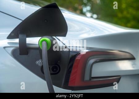 Tesla Model 3 an ein Ladegerät angeschlossen Stockfoto