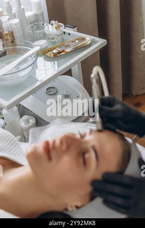 Professionelle Dermatologin in medizinischen Handschuhen führt Mikrodermabrasion auf Frau in einem Schönheitssalon. Hochwertige Fotos Stockfoto