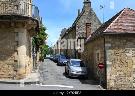 Domme, Frankreich; 17. Juli 2024; Rue des Consuls, Eine enge Straße mit geparkten Autos in der mittelalterlichen bastide-Stadt Domme in der Dordogne Stockfoto