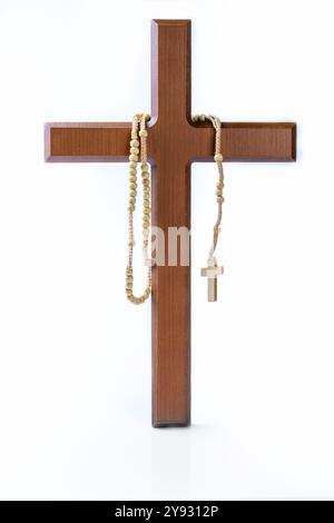 Hölzernes Religionskreuz und Rosenkranzperlen isoliert auf weißem Hintergrund. Christlicher Hintergrund, Gottesdienst, Kirche, Symbole, Gebetskonzept Stockfoto