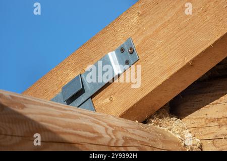 Ein Holzhaus befindet sich im Bau. Verschiebbare Befestigung der Sparren an der Wand, Nahaufnahme mit selektivem Weichfokus Stockfoto