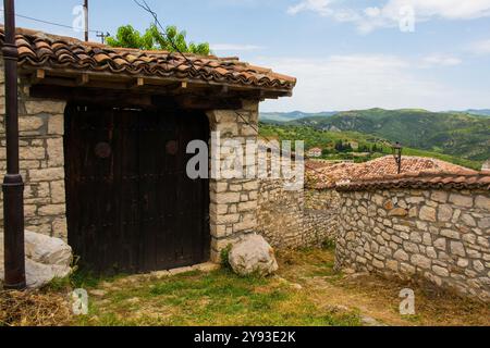 Ein Tor in einer Mauer, das zu einem historischen Wohngebäude innerhalb der Festung Berat im Süden Albaniens gehört. Eine Mischung aus byzantinischem, osmanischem und Stockfoto