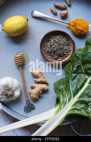 Eine Sammlung natürlicher Kältemittel: Frischer Kurkuma, Ingwer, Knoblauch, Zitrone, Honig, und Kräuter – die Medizinkammer der Natur zur Stärkung der Immunität. Stockfoto