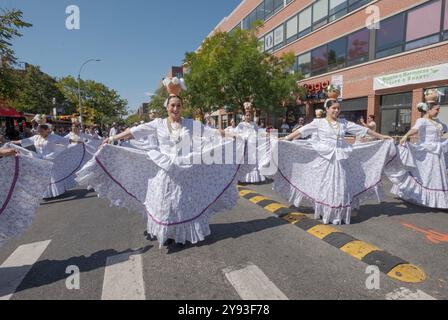 Eine Gruppe paraguayischer Frauen tanzen und marschieren in weißen Kostümen. Bei der Queens Hispanic Day Parade 2024 in Jackson Heights. Stockfoto