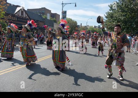 TKSS-Tänzer in fantastischen bunten Kostümen marschieren an der 37th Ave. In Jackson Heights bei der Hispanic Heritage Day Parade. Stockfoto