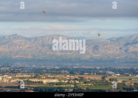 Heißluftballons über den spanischen Städten Rojales und Catral in der Provinz Alicante, Gemeinde Valencia, mit Gebirgszügen dahinter Stockfoto