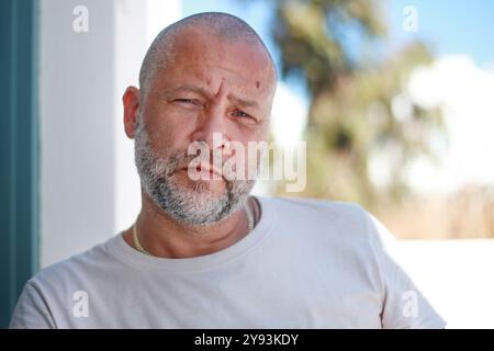 Porträt eines hübschen 50-jährigen Mannes mit unrasierten Haaren in einem weißen T-Shirt Stockfoto