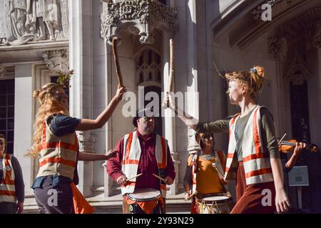 London, Großbritannien. Oktober 2024. Mayday Morris Tänzer treten auf, während Demonstranten sich vor dem Obersten Gerichtshof während der rechtlichen Auseinandersetzung mit Dartmoor Wildcamping versammeln. Zwei Grundbesitzer fordern das Urteil des Berufungsgerichts an, wonach die Öffentlichkeit das Recht hat, in Teilen des Dartmoor-Nationalparks, die sich in Privatbesitz befinden, wilde Camps zu betreiben. Quelle: Vuk Valcic/Alamy Live News Stockfoto