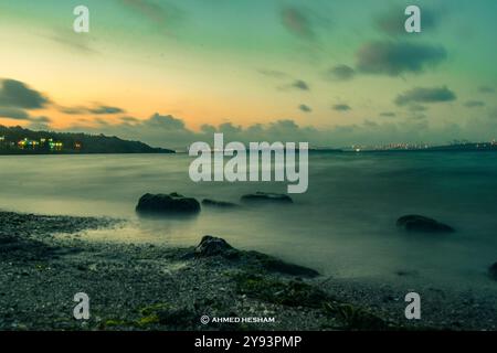 Das Bild zeigt eine ruhige Abendszene in einer Bucht. Die Langzeitbelichtungstechnik wurde verwendet, um einen glatten, fast ätherischen Effekt o zu erzeugen Stockfoto
